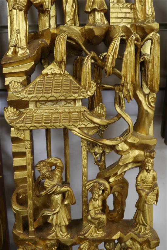 Three Chinese carved giltwood panels of figures amid pavilions